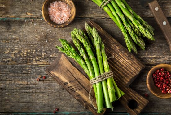 Bündel aus frischem grünen Spargel auf Holzuntergrund im Restaurant Gourmetfabrik Schwerin