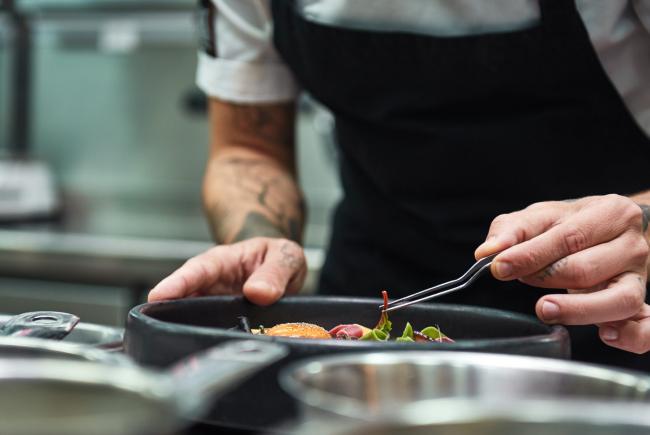Hände des Küchenchefs der Pasta Carbonara in der Restaurantkuche vom Restaurant Gourmetfabrik Schwerin garniert