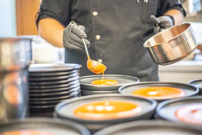 Koch garniert Kürbiskernsuppe im Restaurant Gourmetfabrik Schwerin